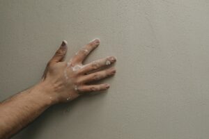 hand on a newly painted wall